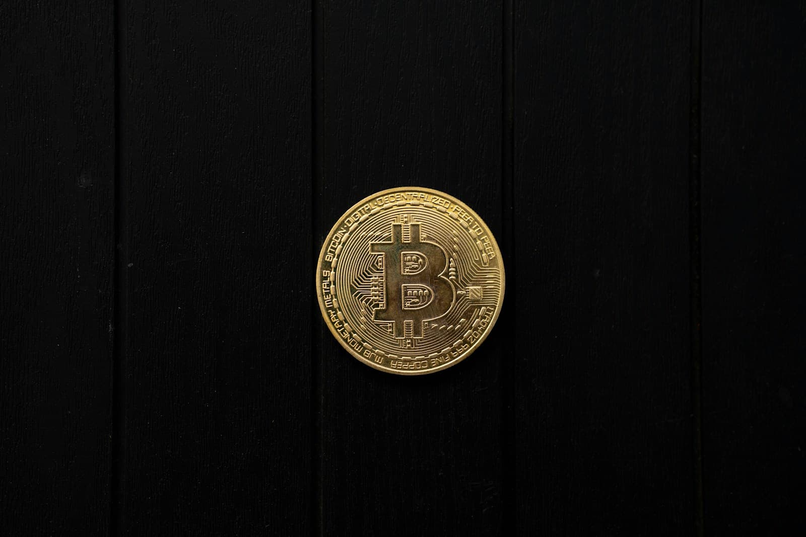 Gold Bitcoin coin on dark background, representing crypto business banking
